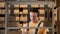 Portrait of male working in storage. Man storekeeper standing near rack talking in headset puts boxes on the shelf