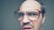 Portrait. malicious bald mustachioed man with glasses swears looking at camera