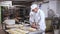 Portrait of man baker working with dough and forming baguettes