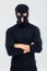 Portrait of man in balaclava standing with arms crossed