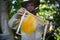 Portrait of man beekeeper holding new honeycomb frame in apiary.