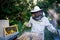 Portrait of man beekeeper working in apiary.