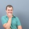 Portrait of a man biting nails and being scared against gray background