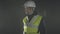 Portrait of the man in the builders uniform and helmet looking around on a black background in the workplace.