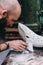 Portrait of man carefully work on a ceramic whale in workshop.