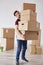 Portrait of man carrying stack of heavy cardboard boxes