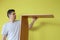 Portrait of man is collecting parts of computer table screwing shelf.