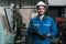 Portrait of man engineering standing at factory with holding big wrench tool and looking at camera