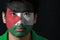 Portrait of a man with the flag of the Palestine painted on his face on black background.