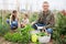 Portrait of man gardener with harvest of vegetables and greens in basket