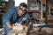 Portrait of a man in goggles blows sawdust from the Board when woodworking planer