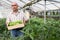 Portrait of man horticulturist holding crate with green okra