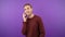 portrait of a man on an isolated purple background talking on the phone. 4K