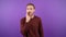 portrait of a man on an isolated purple background whispering a secret, 4K