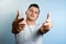 Portrait of a man on a light background close-up. Emotion importance, shows the hand gesture of the gun in the camera. The concept