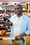 Portrait of man looking at wine bottle in grocery section