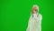 Portrait of man medic on chroma key green screen. Close side view senior doctor in white coat walking talking on