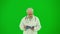 Portrait of man medic on chroma key green screen. Close up senior doctor in uniform walking reading documents in