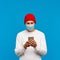 Portrait of man with medical protective face mask, texting on mobile phone. Male write message