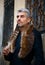 Portrait of a man and Portrait of a man and wolf furry and eagle feathers, and ornamental medieval window on background.