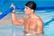 Portrait Of A Man Posing In Swimming Pool. Portrait Of A Young Wet Muscular Man Standing In Swimming Pool.