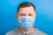 Portrait of man in protective mask with pandemic text at blue background. and health care concept