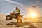 Portrait of man quad biking in dessert with lens flare