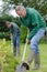 Portrait man shoveling in garden