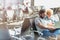 Portrait of man showing funny picture with his wife while waiting in airport