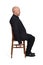 Portrait of a man sitting on a chair side view on  white background