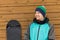 Portrait man with snowboard and hat and splitboard near wooden wall