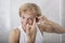 Portrait of man squeezing pimple on his forehead in bathroom