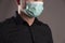 Portrait of a man with surgical protection mask on gray background. Coronavirus concept. Protect your health