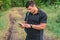 Portrait of a man traveller searching connection on the phone in the forest.