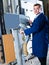 portrait of man in uniform working on large automatic saw machinery indoors