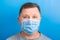 Portrait of man wearing medical mask with epidemic word at blue background. concept. Respiratory protection