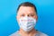 Portrait of man wearing medical mask Stay home at blue background. Coronavirus self isolation concept. Respiratory protection