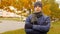 Portrait of man wearing scarf and hat in the fall or autumn outside, in city