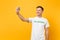 Portrait of man in white t-shirt written inscription green title volunteer taking selfie shot on mobile phone isolated