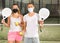 Portrait of man and woman in masks posing with padel rackets