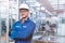 Portrait of manual man worker is standing with confident with blue working suite dress and safety helmet in front the glass wall