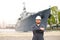 Portrait of marine captain standing near big vessel in background, holding walkie talkie.