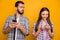 Portrait of married couple woman use smartphone read social network news man look feel jealous wear casual checkered
