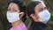 Portrait of a masked woman and teenager against a virus.