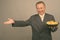 Portrait of mature Asian businessman with bowl of potato chips