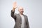 Portrait of a mature bald man in suit wave hand welcome. Human emotion expression and lifestyle concept.