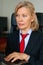 Portrait of mature boss woman in red tie at office