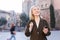 Portrait of mature cheerful woman standing on a old city street