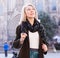 Portrait of mature cheerful woman standing on a old city street