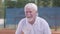 Portrait of a mature confident concentrated man standing on a tennis court ready to play. Recreation and leisure